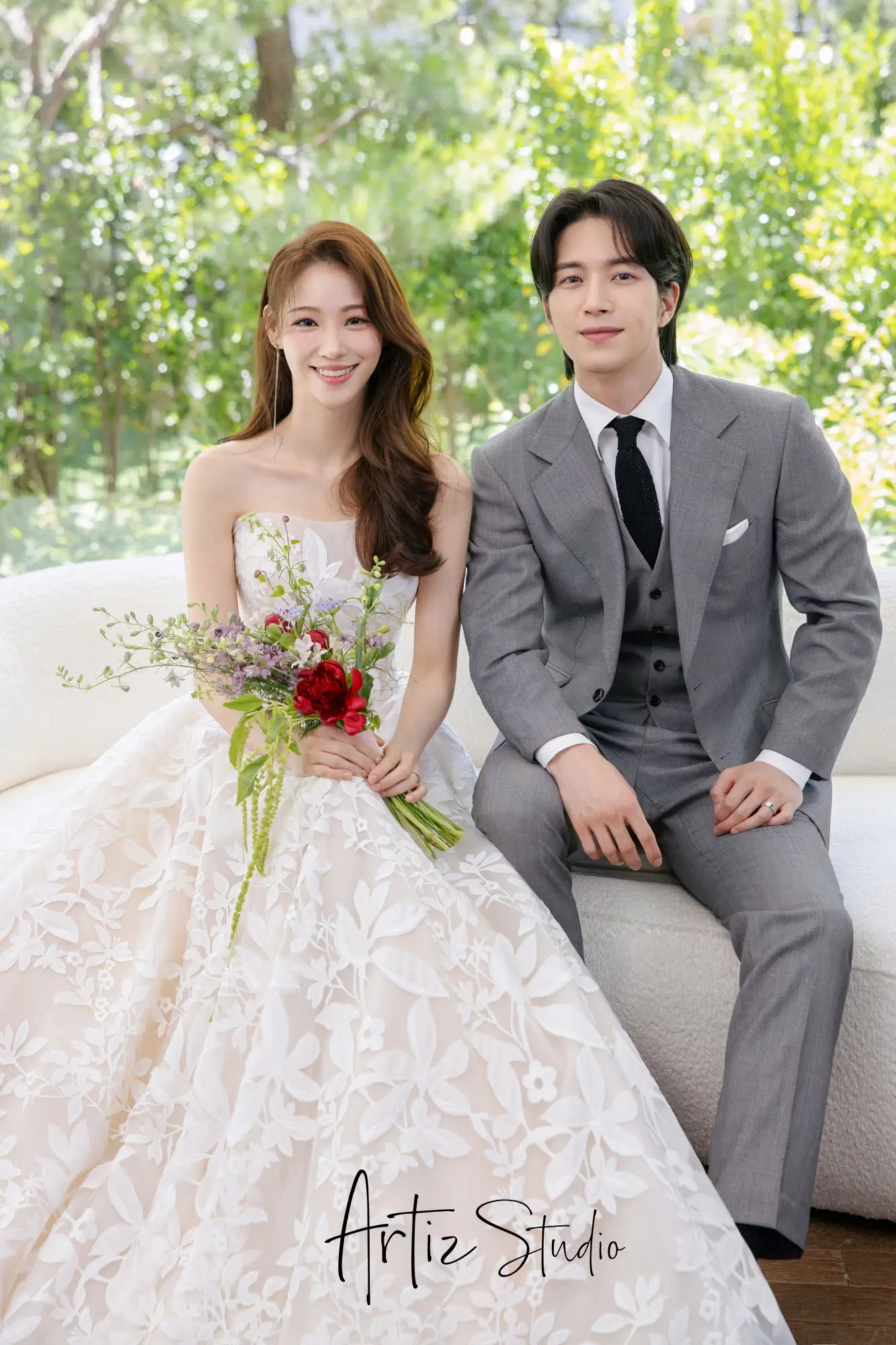 A groom with his bride, who is wearing a magnificent embroidered wedding dress