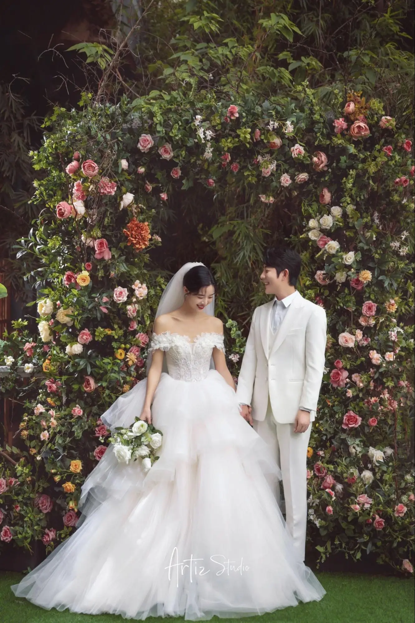 An image of a couple, with the bride wearing an ultra-feminine wedding dress